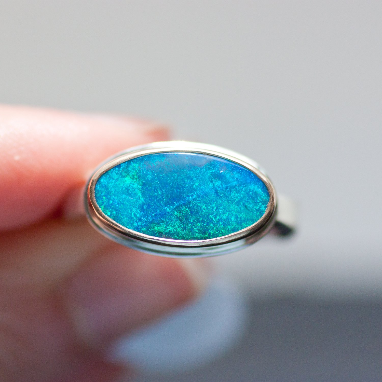 Jamie Joseph: SS & 14k gold ring with small oval Australian opal on medium live edge band