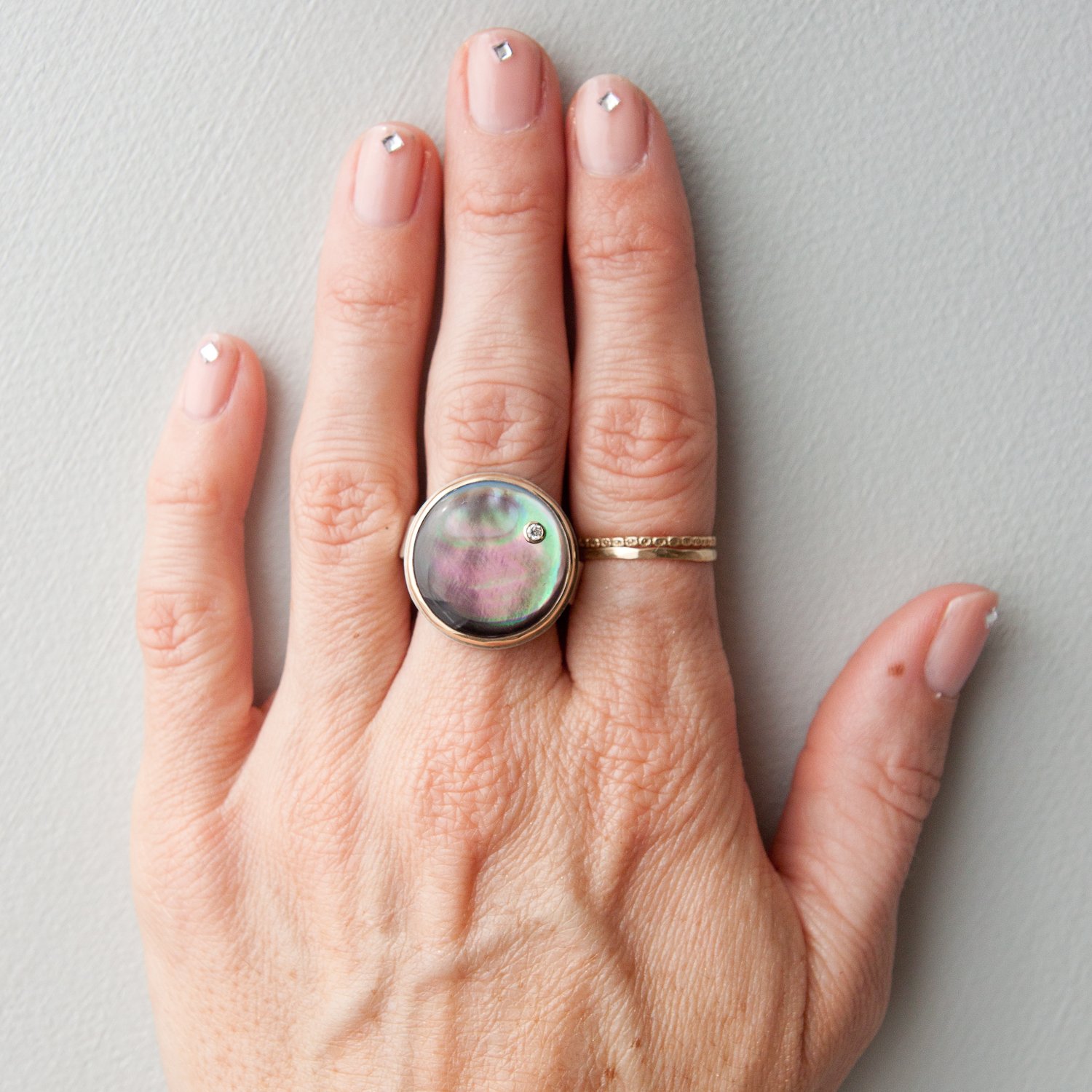 Jamie Joseph: SS and 14K gold ring with round smooth black mother of pearl and .03ct diamond on pumice band size 7.25