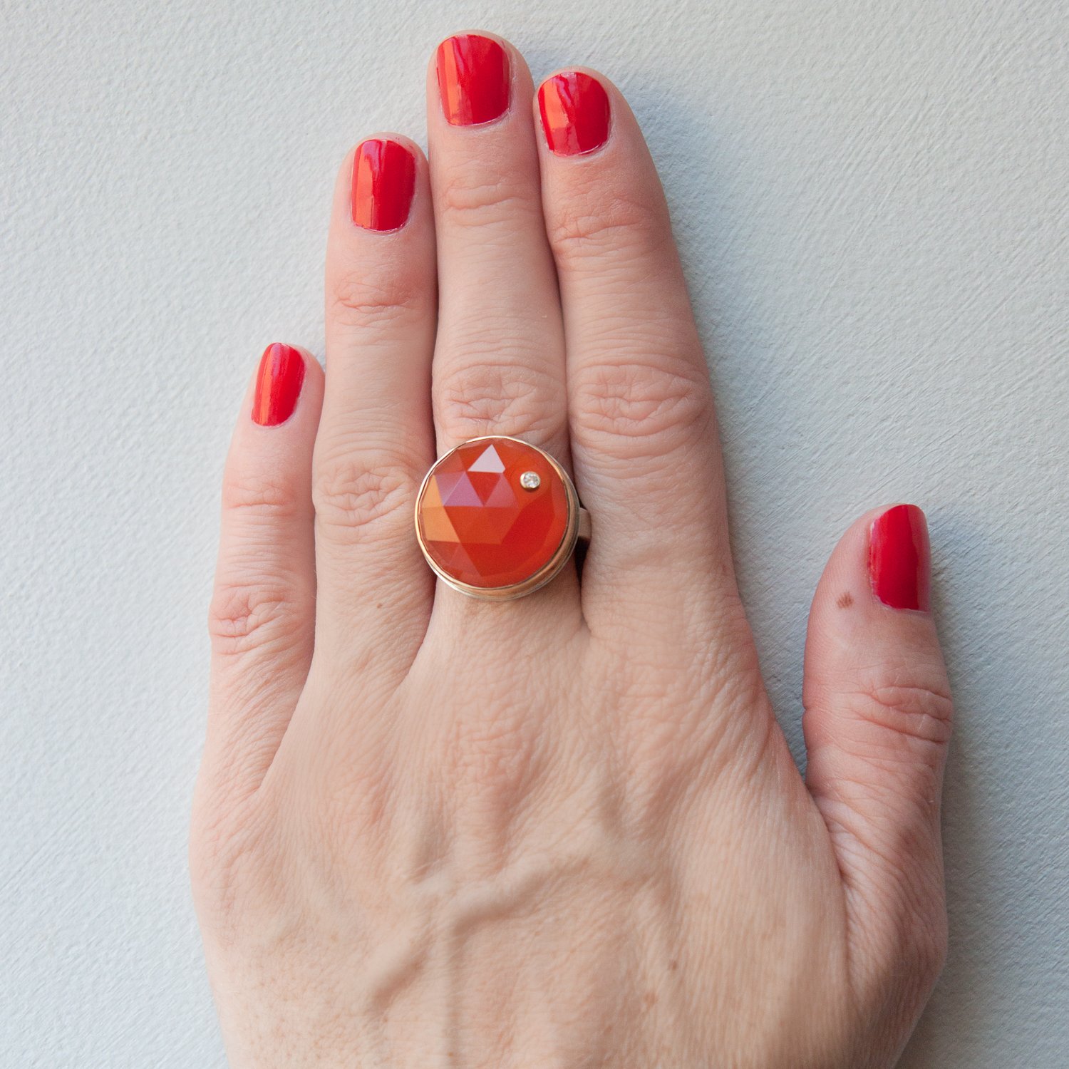 Jamie Joseph: SS & 14k gold ring with round rose cut orange chalcedony and .03ct diamond on skinny smooth band