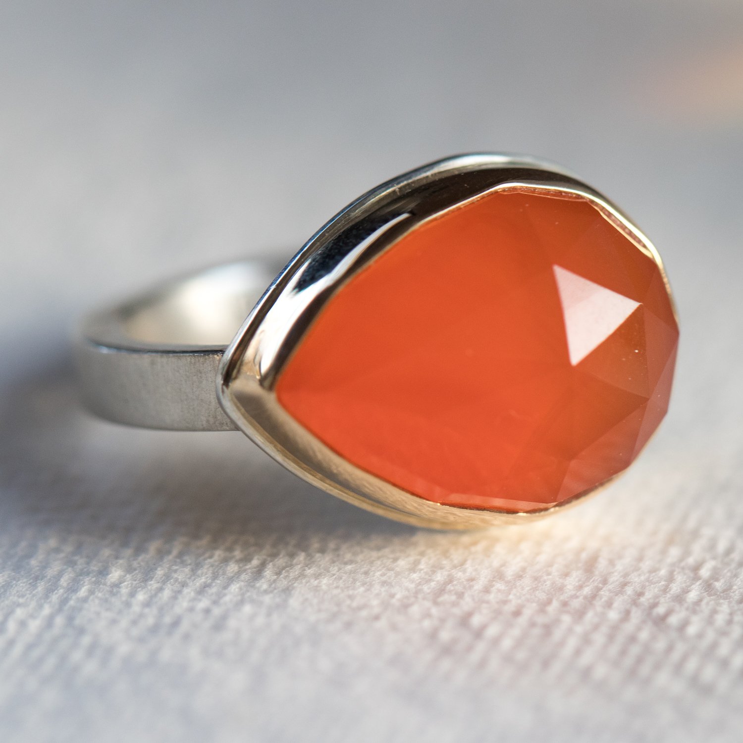 Jamie Joseph: SS & 14K gold ring w/ teardrop rose cut orange chalcedoney on x band sz 6.5