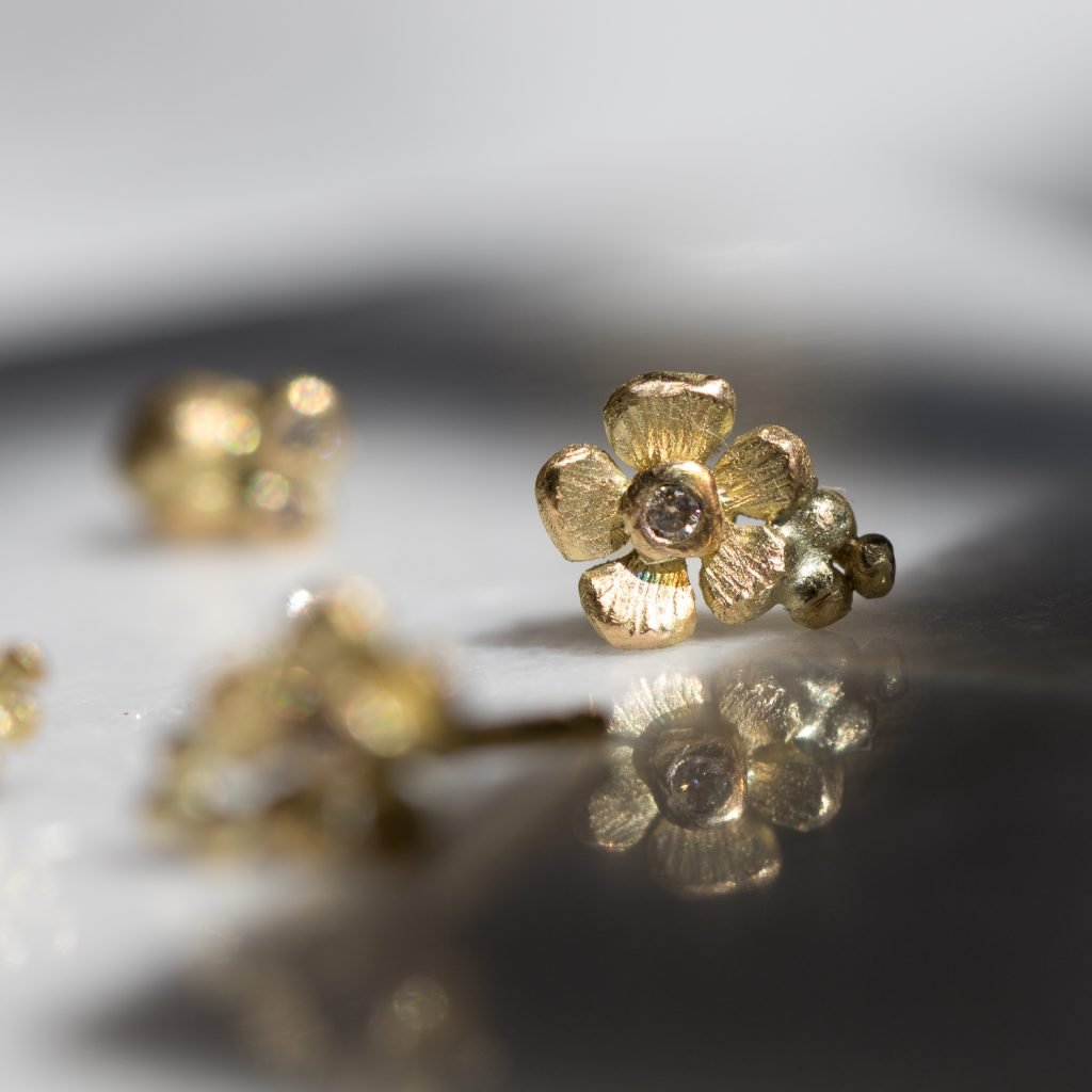 Gold flower post earrings with diamond center by Lene Vibe