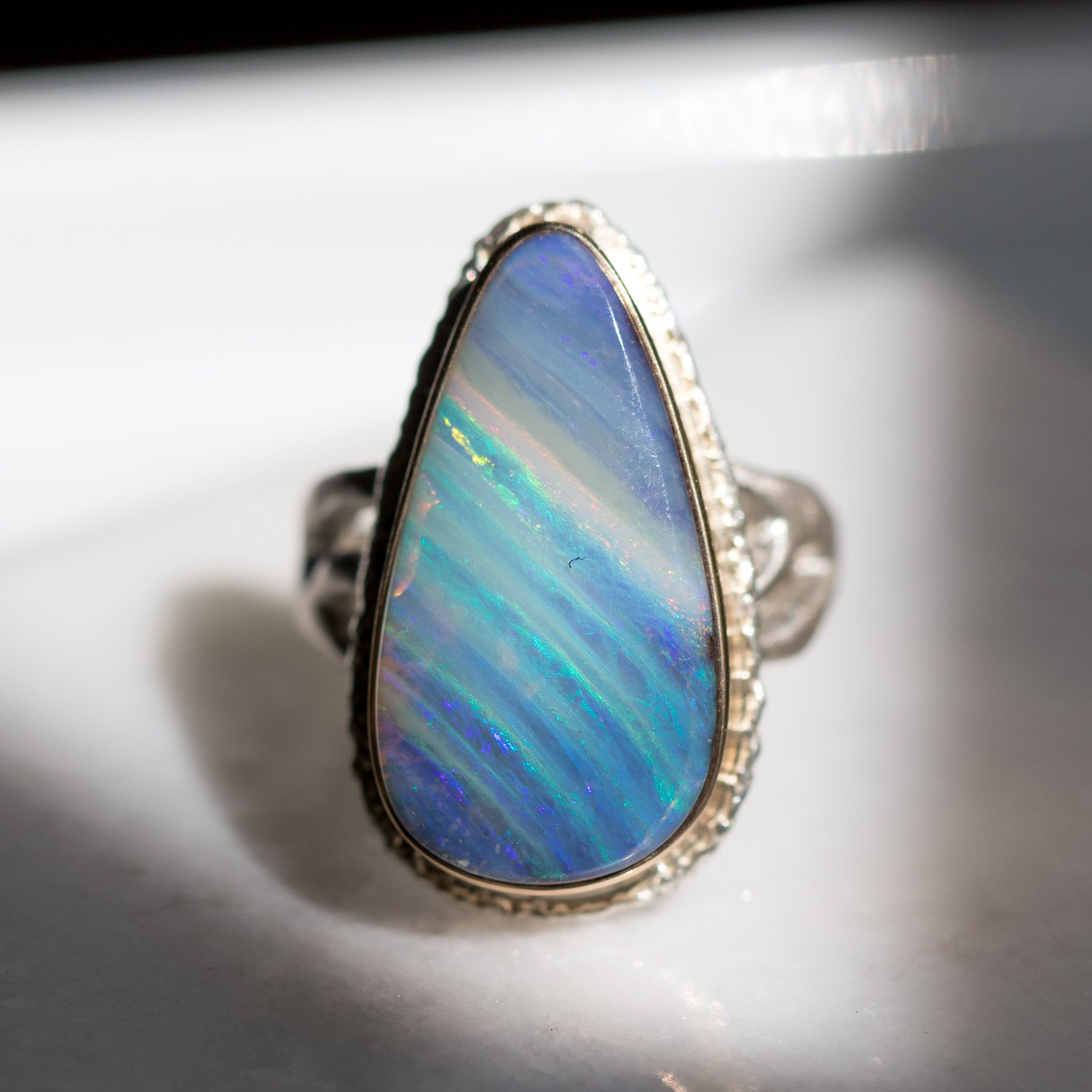 Jamie Joseph: SS and 14k Gold Ring w/ teardrop boulder opal on lava platform/madrona band