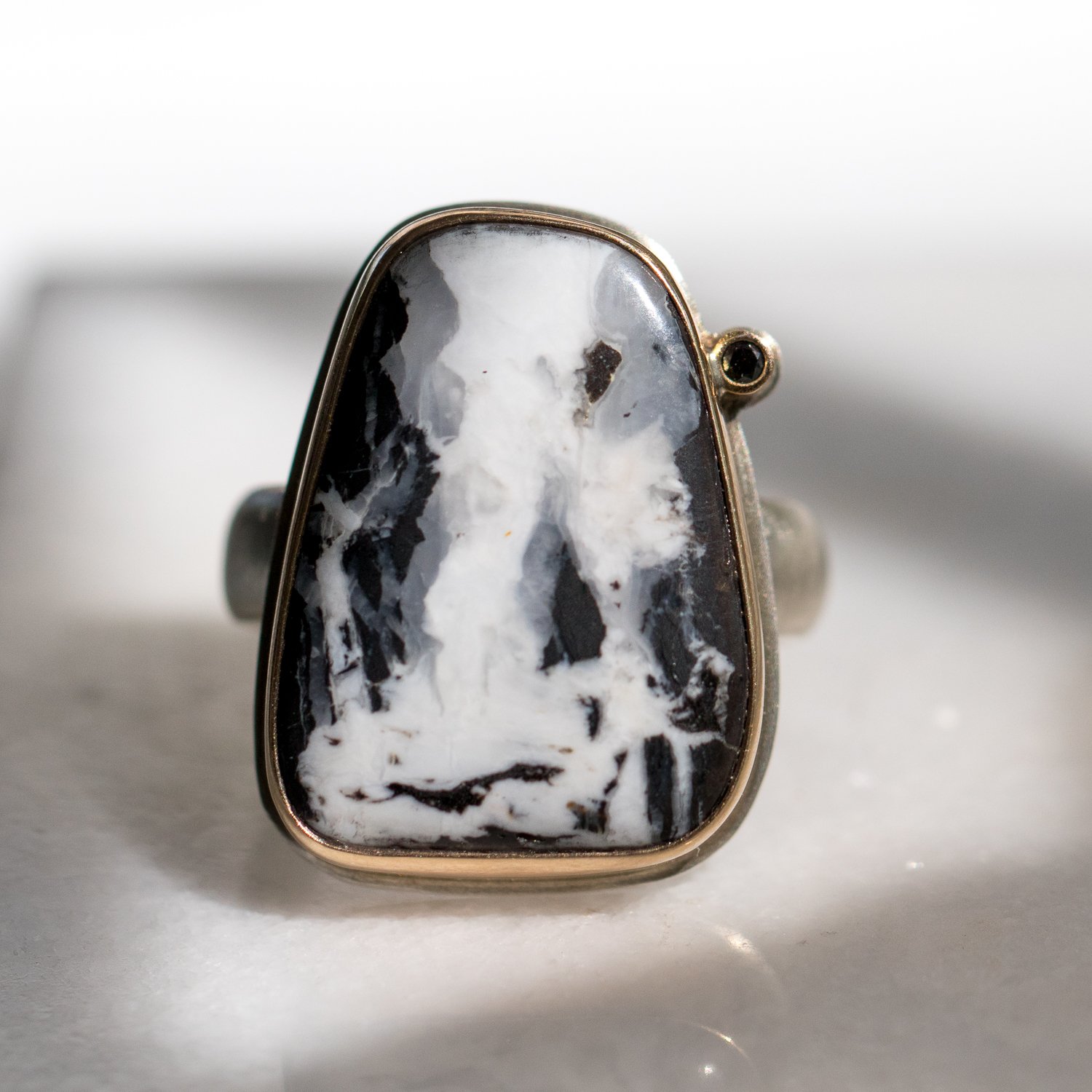 Jamie Joseph: SS and 14k Gold Ring w/ asymmetrical white buffalo turquoise and .025 black satellite diamond on comfort band