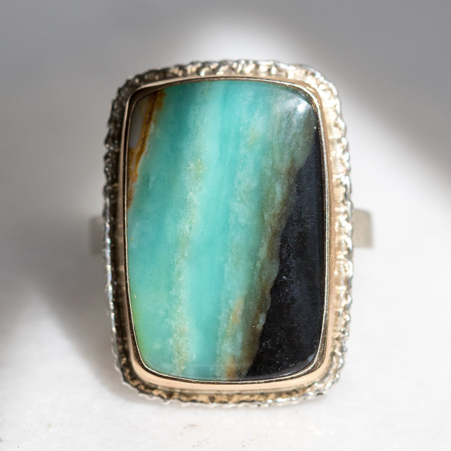 Jamie Joseph: Sterling & 14K gold ring w/vertical rectangular Indonesian Blue Fossilized Opalized Wood on lava platform and X band