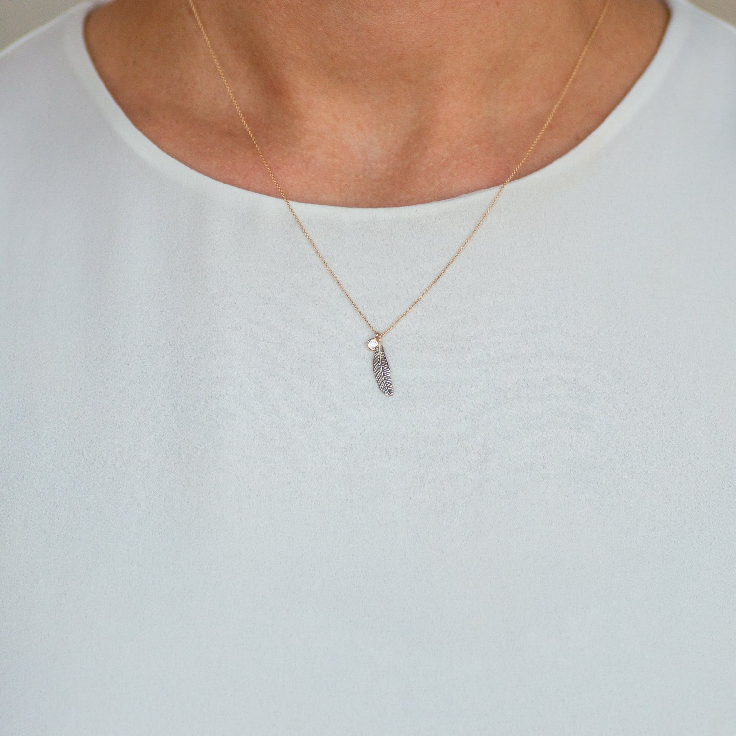 Kismet: 14K yellow gold mini raven feather necklace with single white diamond .04ct