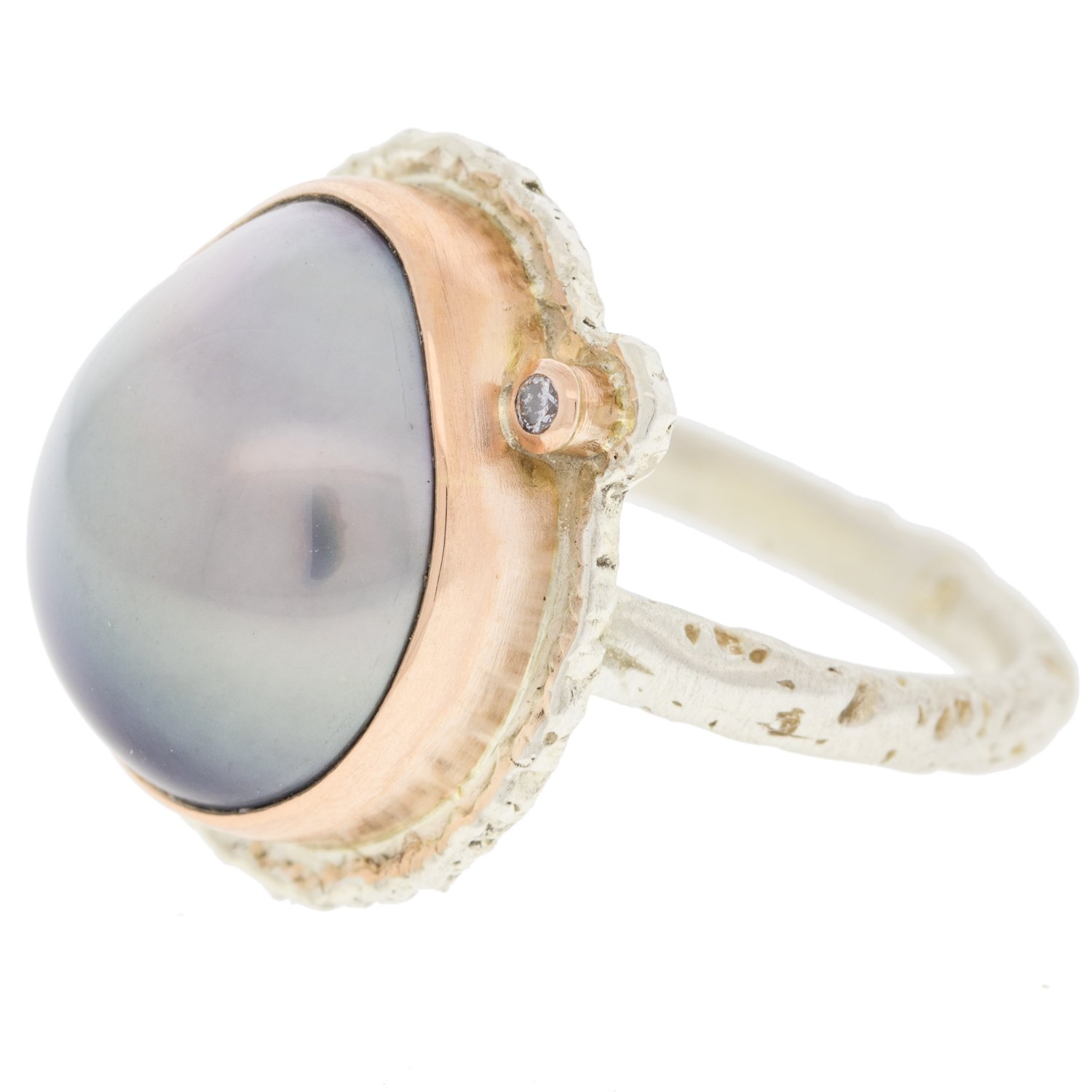 Jamie Joseph: SS and 14K rose gold ring with vertical asymmetrical Tahitian pearl and .025ct satellite diamond on lava platform and textured band size 7.5 5/8x1/2