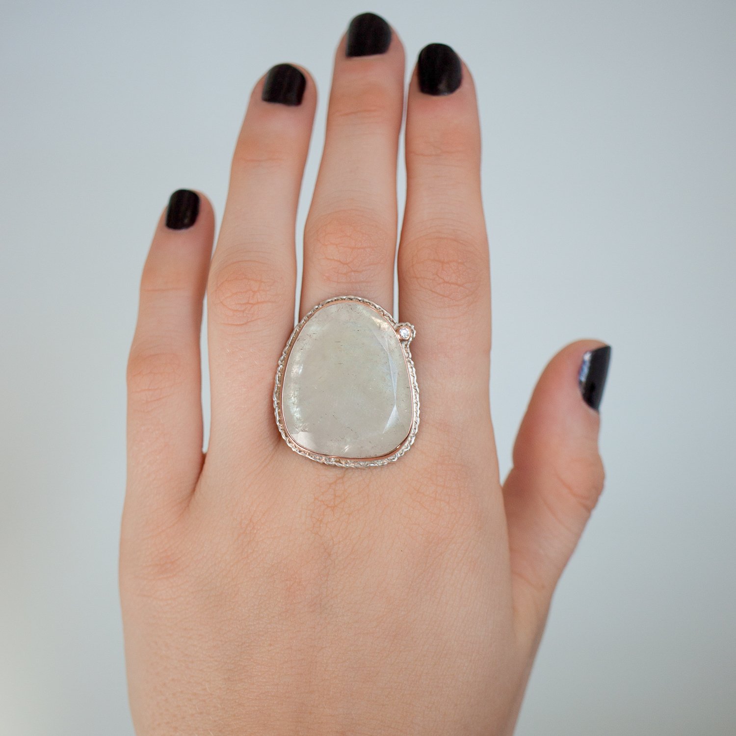 Jamie Joseph: SS and 14K rose gold ring with large vertical asymmetrical table cut linen sapphire and .03ct satellite diamond on lava platform and tapered Y band size 7.5 1 1/16x7/8