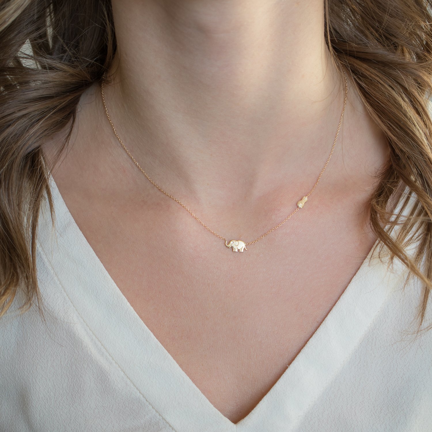 Victoria Cunningham: Necklace, Tiny elephant and peanut, 14K yellow gold.