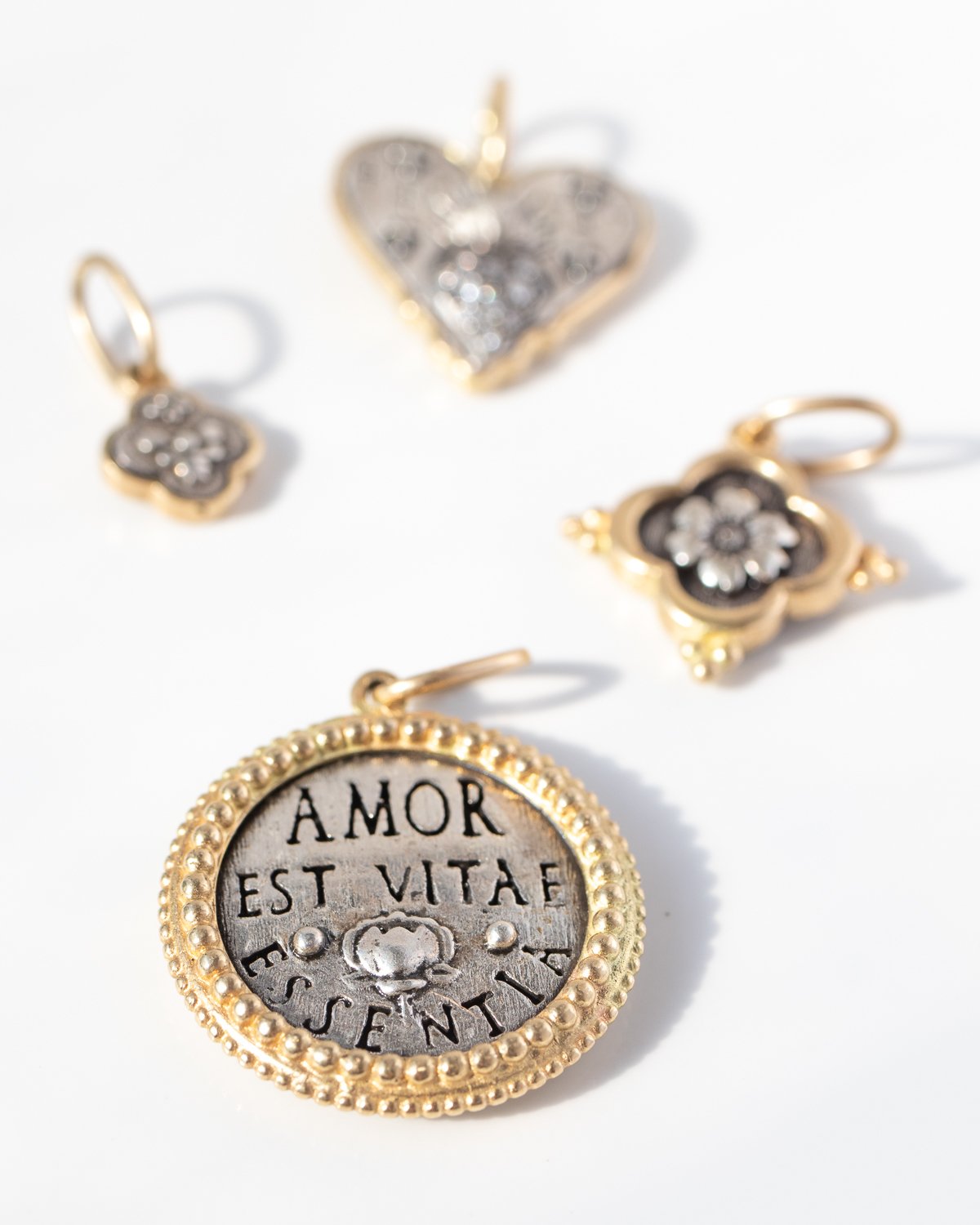 Gold, silver, and enamel necklace charms by jewelry designer Erica Molinari