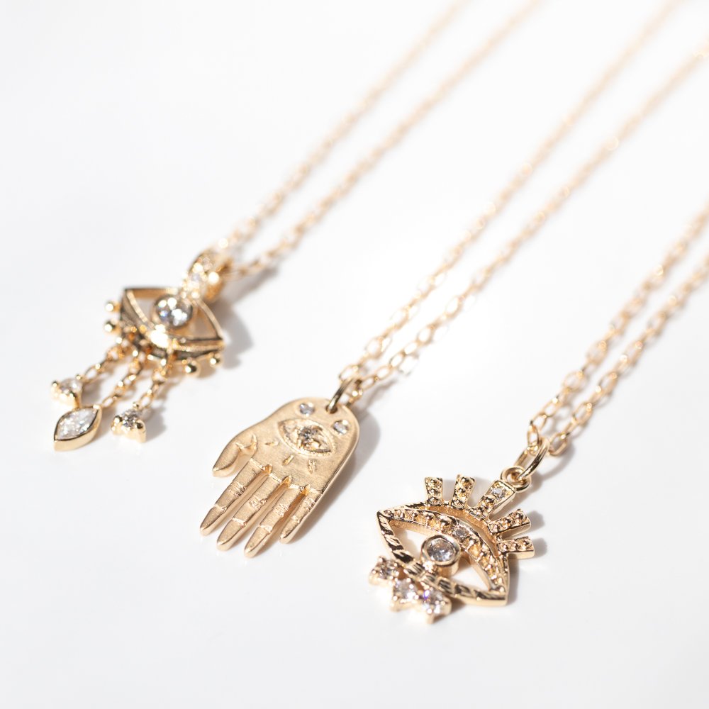 Gold and diamond eye and tiny hand necklaces by jewelry designer Celine Daoust
