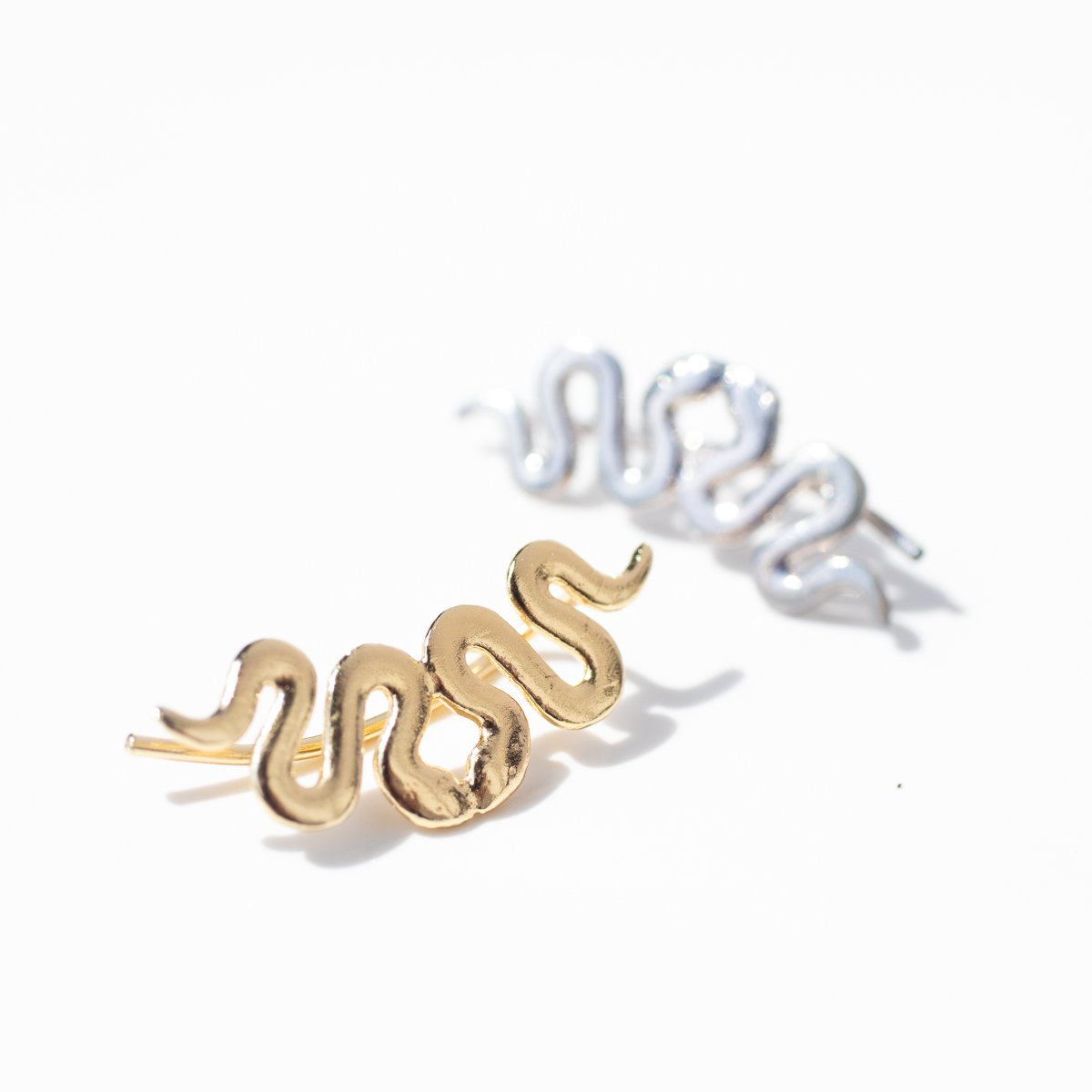 Snake ear climber earrings in gold and snake ear climber earrings in silver by jewelry designer Lauren Newton