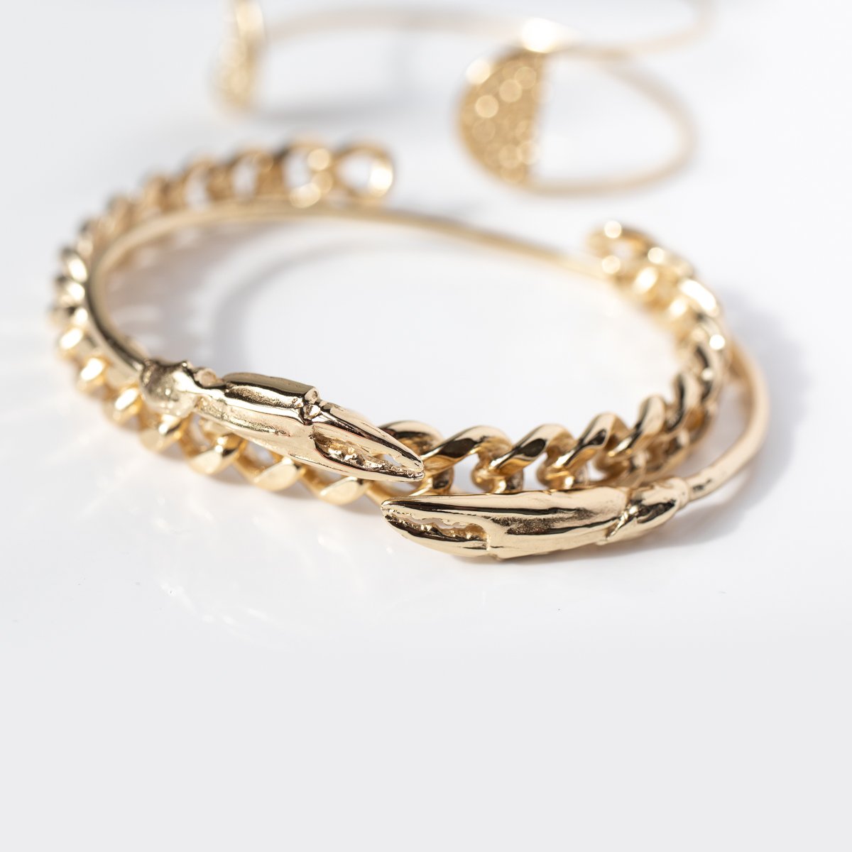 Gold chain cuff and crab claw cuff by jewelry designer Lauren Newton