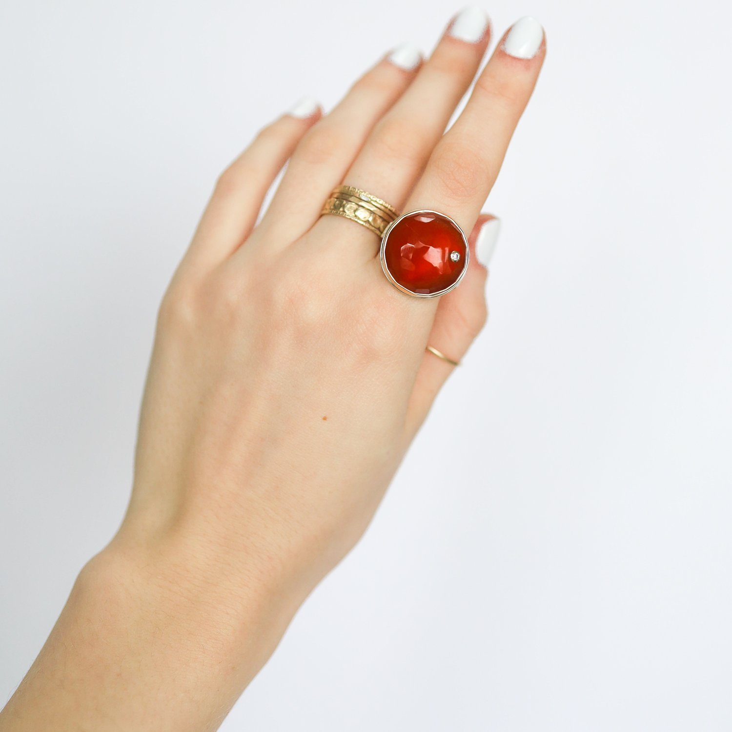 Jamie Joseph: Ring, Round hand faceted, 14K yellow gold bezel set carnelian, Diamond, .03ct, Sterling silver live edge band, Stone measures 3/4 in diameter, Currently available in size 7.75