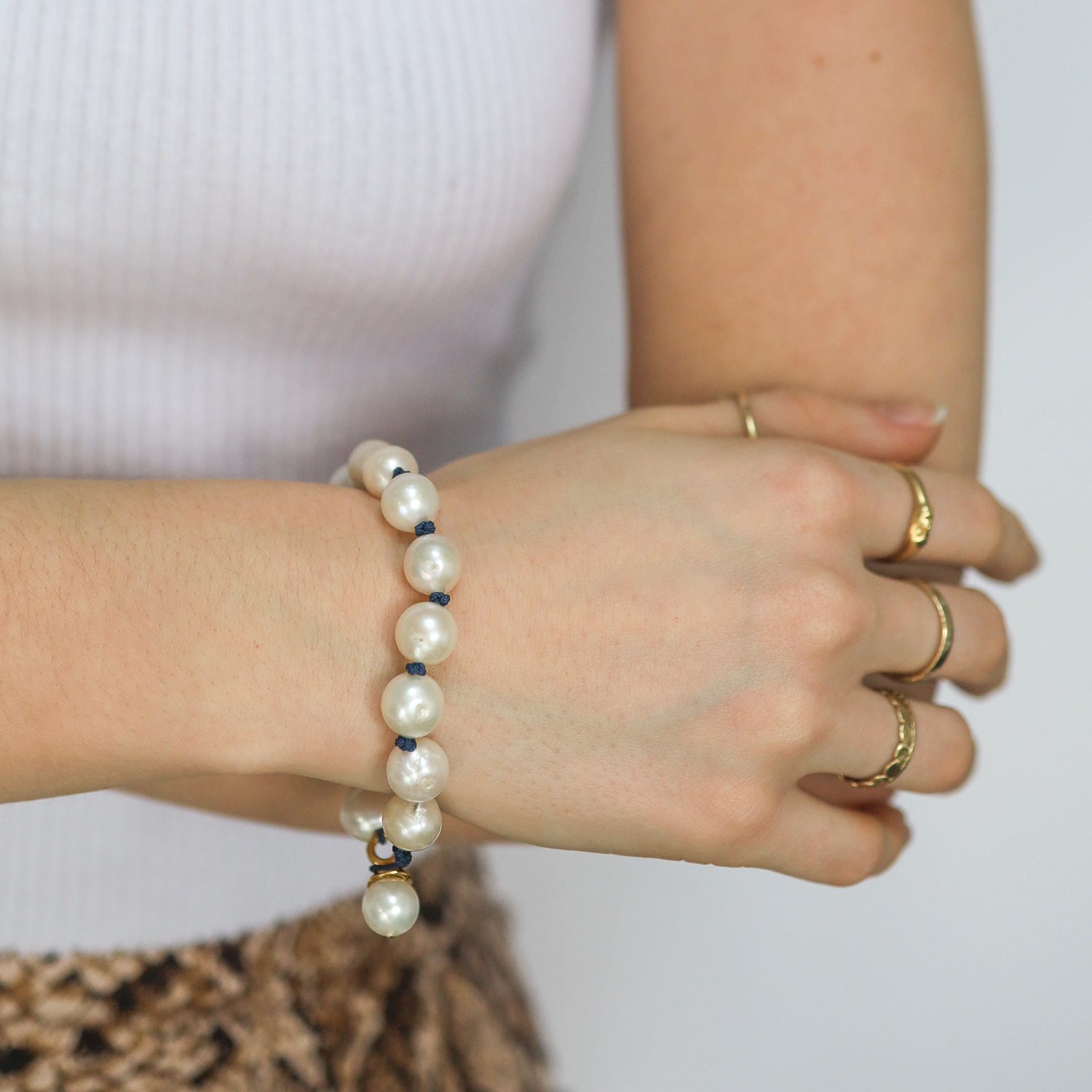 Catherine Canino: Large white freshwater pearl knotted bracelet with navy cord and polished 14K over brass detail