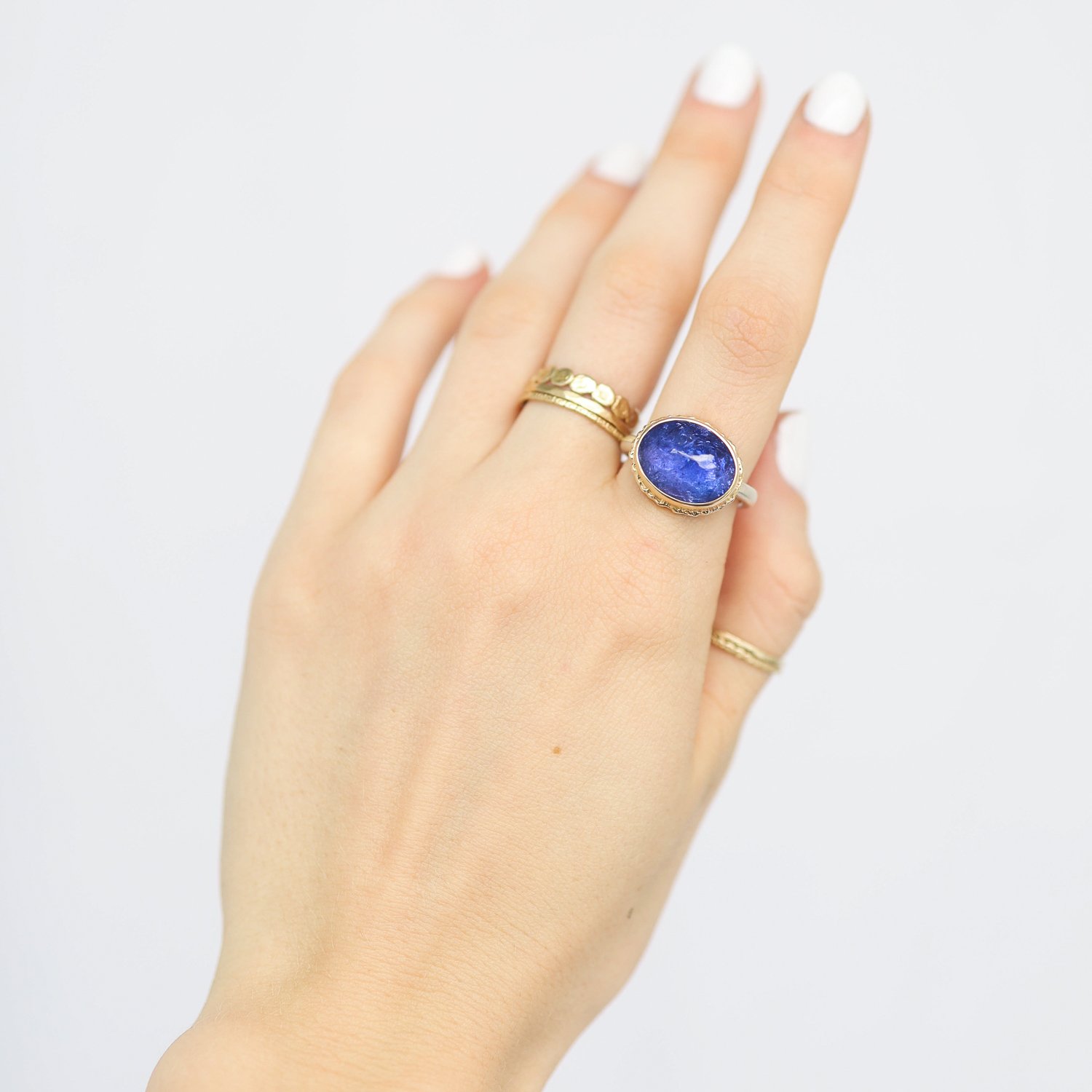 Jamie Joseph: Ring, Oval inverted, 14K yellow gold bezel set tanzanite on ruffled platform, Sterling silver Egyptian band, Stone measures 7/16 x 9/16, Currently available in size 6 3/4