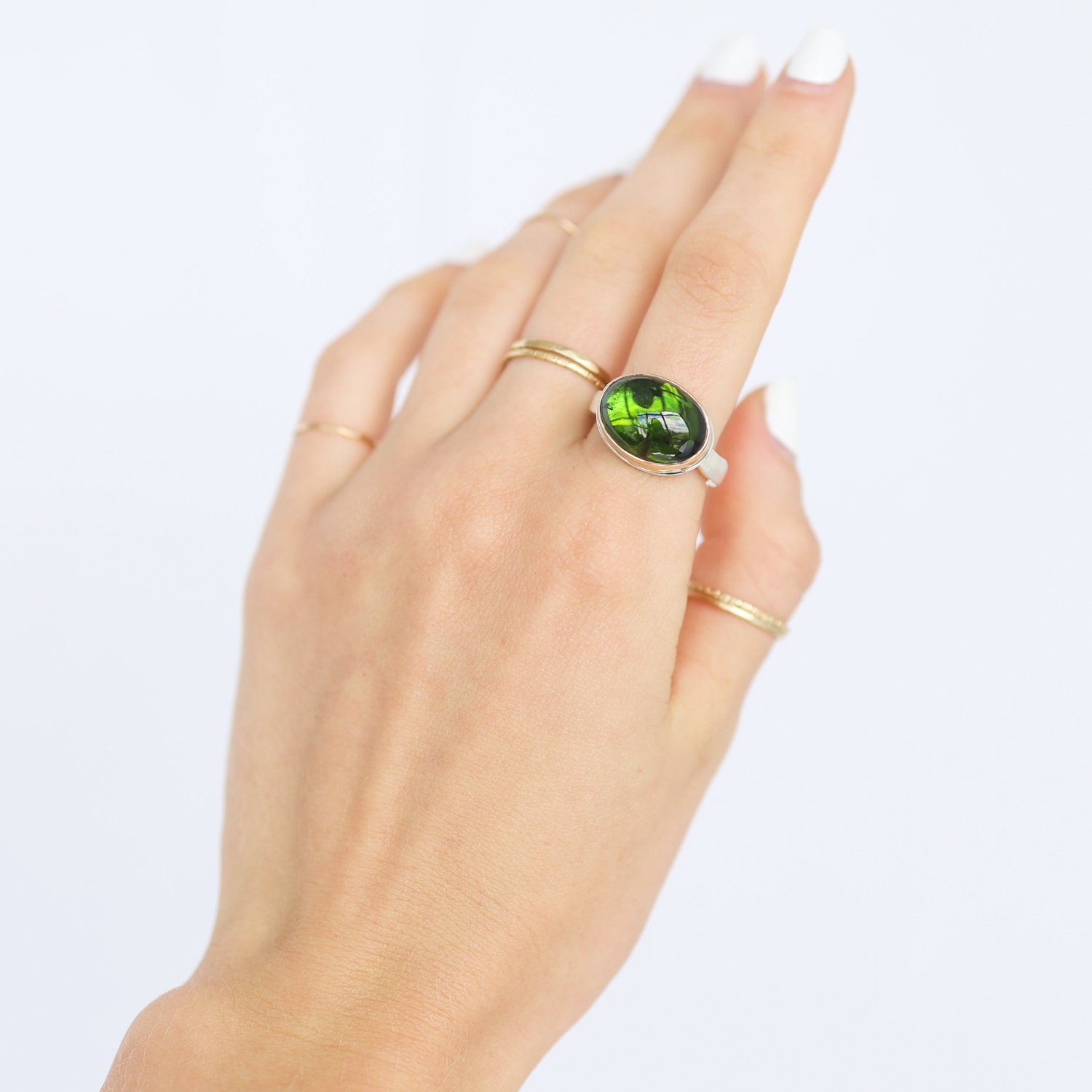 Jamie Joseph: Ring, Small oval smooth, 14K gold bezel set green tourmaline, Sterling silver soft live edge band, Stone measures 7/16 x 9/16, Currently available in size 7 1/4