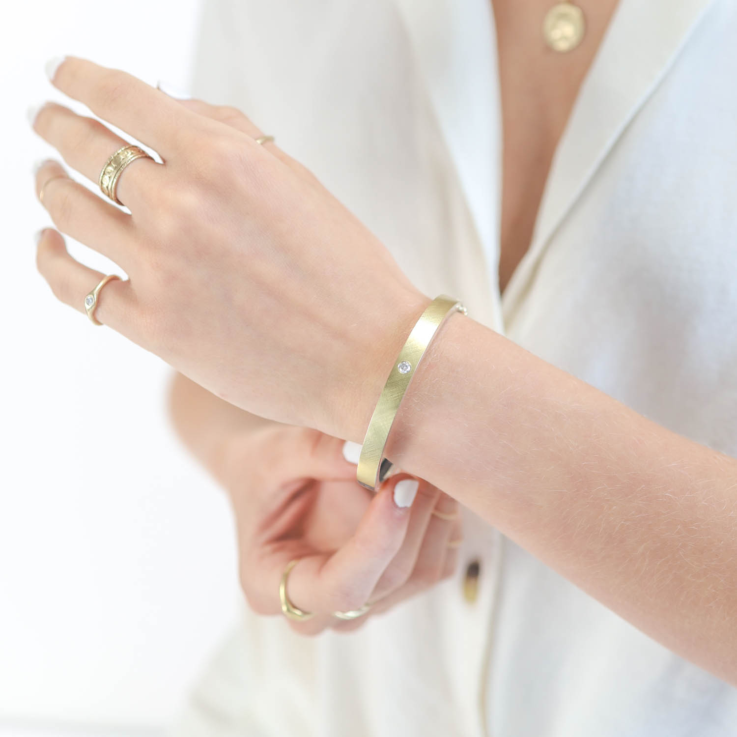 Rene Escobar: Sterling silver bangle with 18K yellow gold top and bottom with single flush set diamond