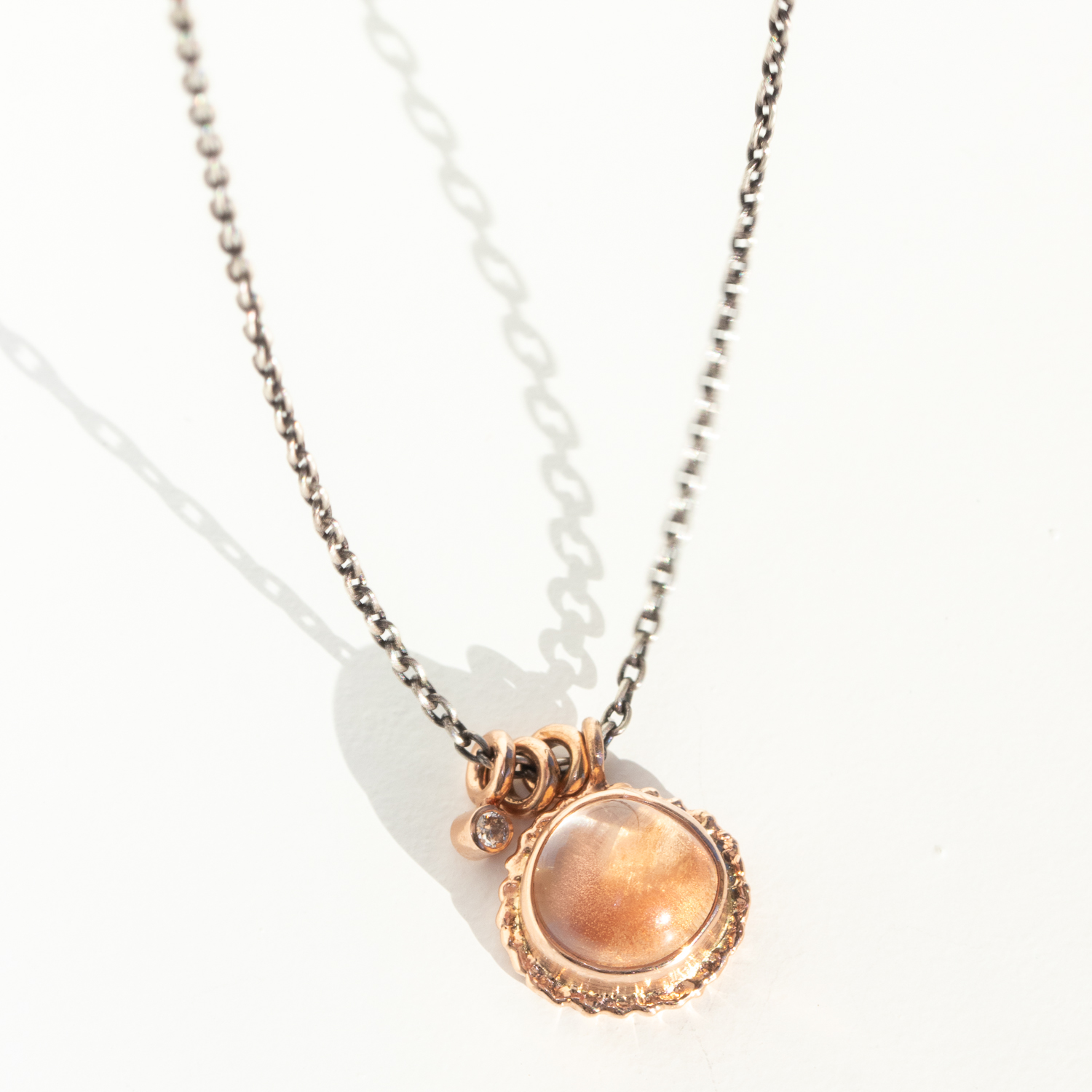Jamie Joseph Trunk Show: Oxidized Sterling & 14K Rose Gold Necklace w/ Round Smooth OREGON SUNSTONE on Ruffled Platform w/ .025 ct Diamond Accent & Sliding Rings (17.5")