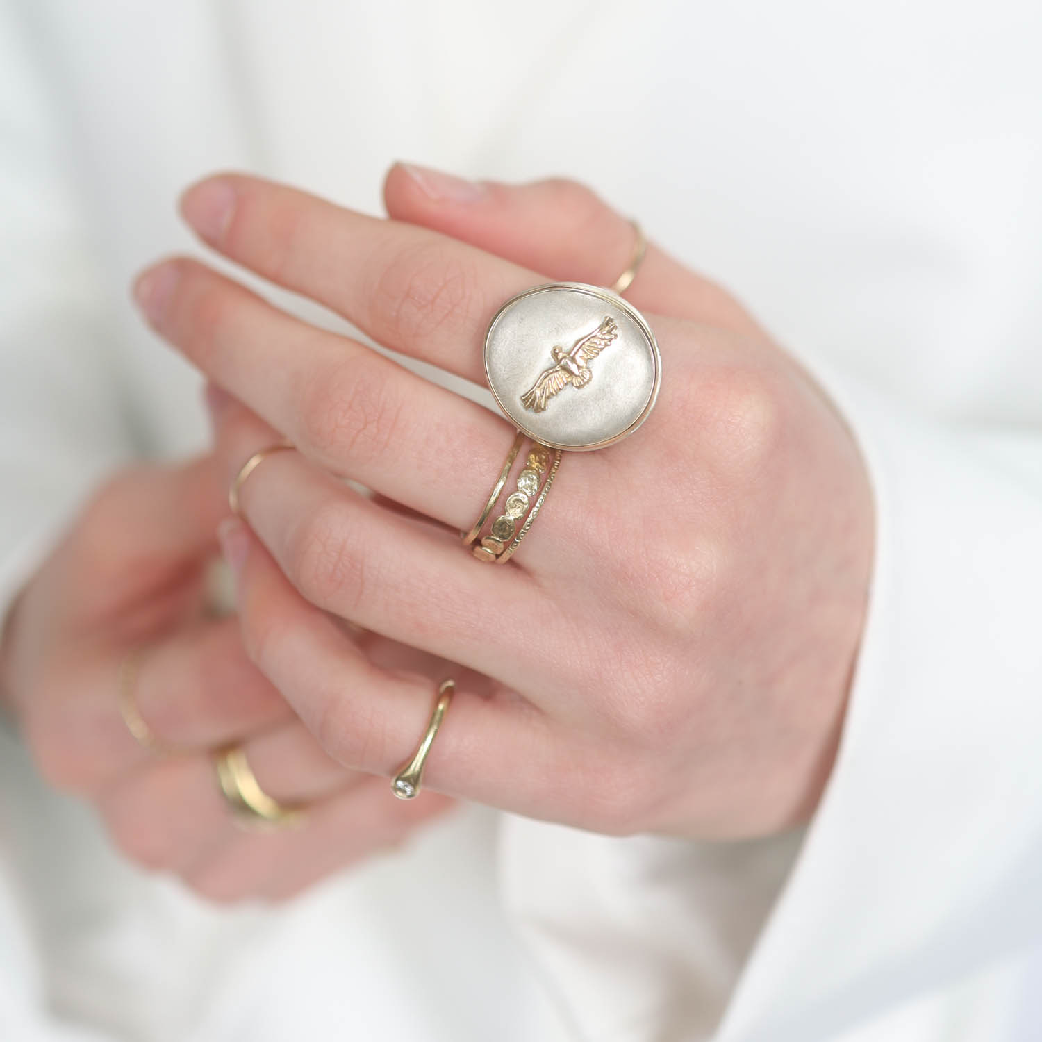 Jamie Joseph: Ring, Vertical asymmetrical, 14K bezel set Eagle on open back platform, Hidden feather charm, Sterling silver band, Measures 7/8 x 3/4 size 7