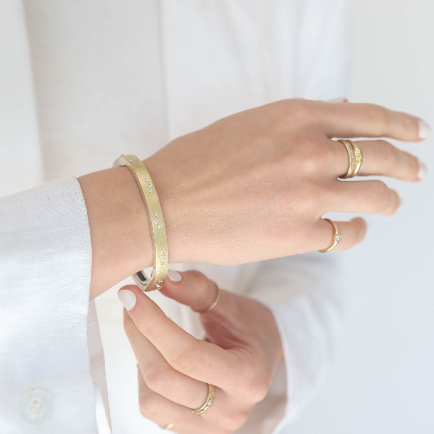 Rene Escobar: Bangle, MARU, 6mm in width, Yellow Gold front, Oxidized sterling silver back, FIVE diamond clusters Diamonds .38, Size medium.