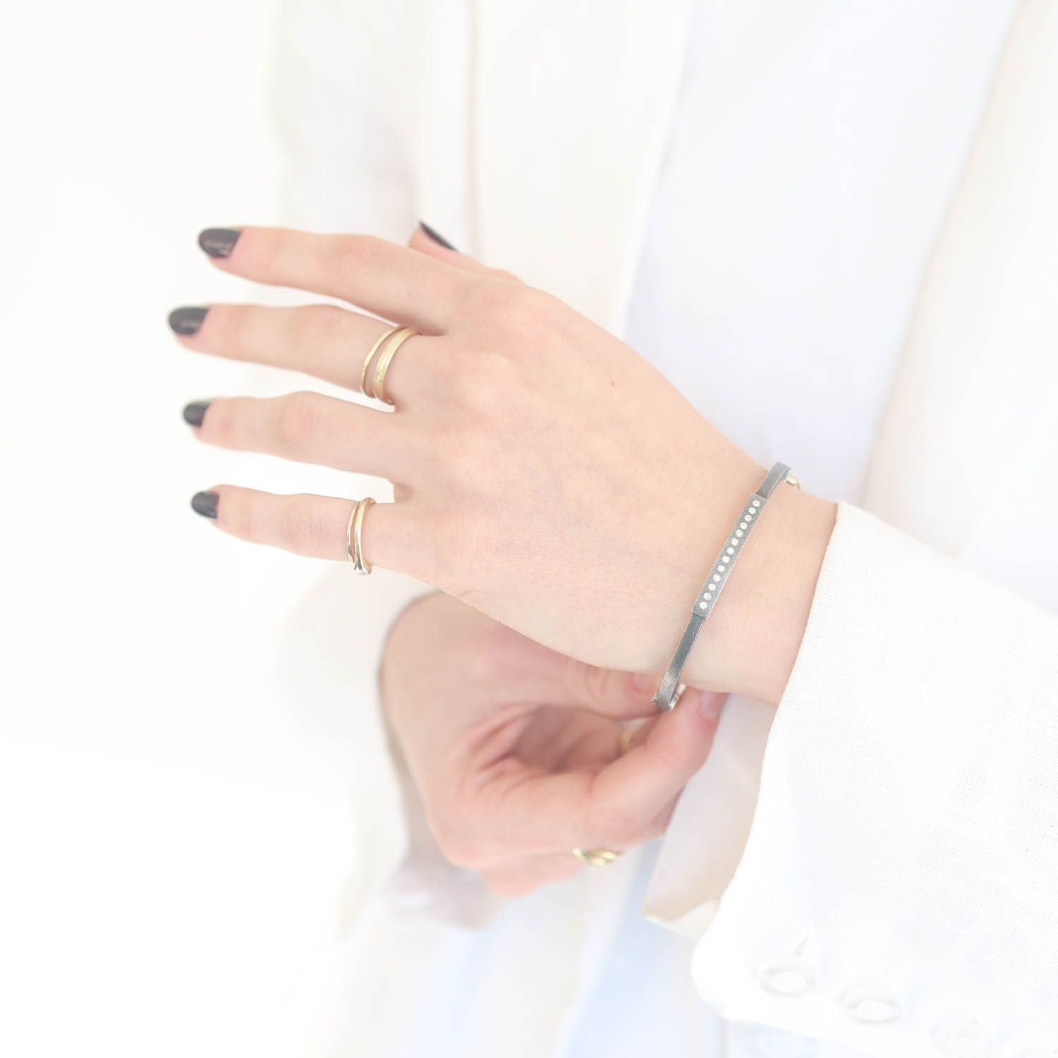 Rene Escobar Trunk Show:12 2.5MM. SS hinged bangle featuring an 18k YG push button style clasp set with 0.13CT weight of WH diamonds.