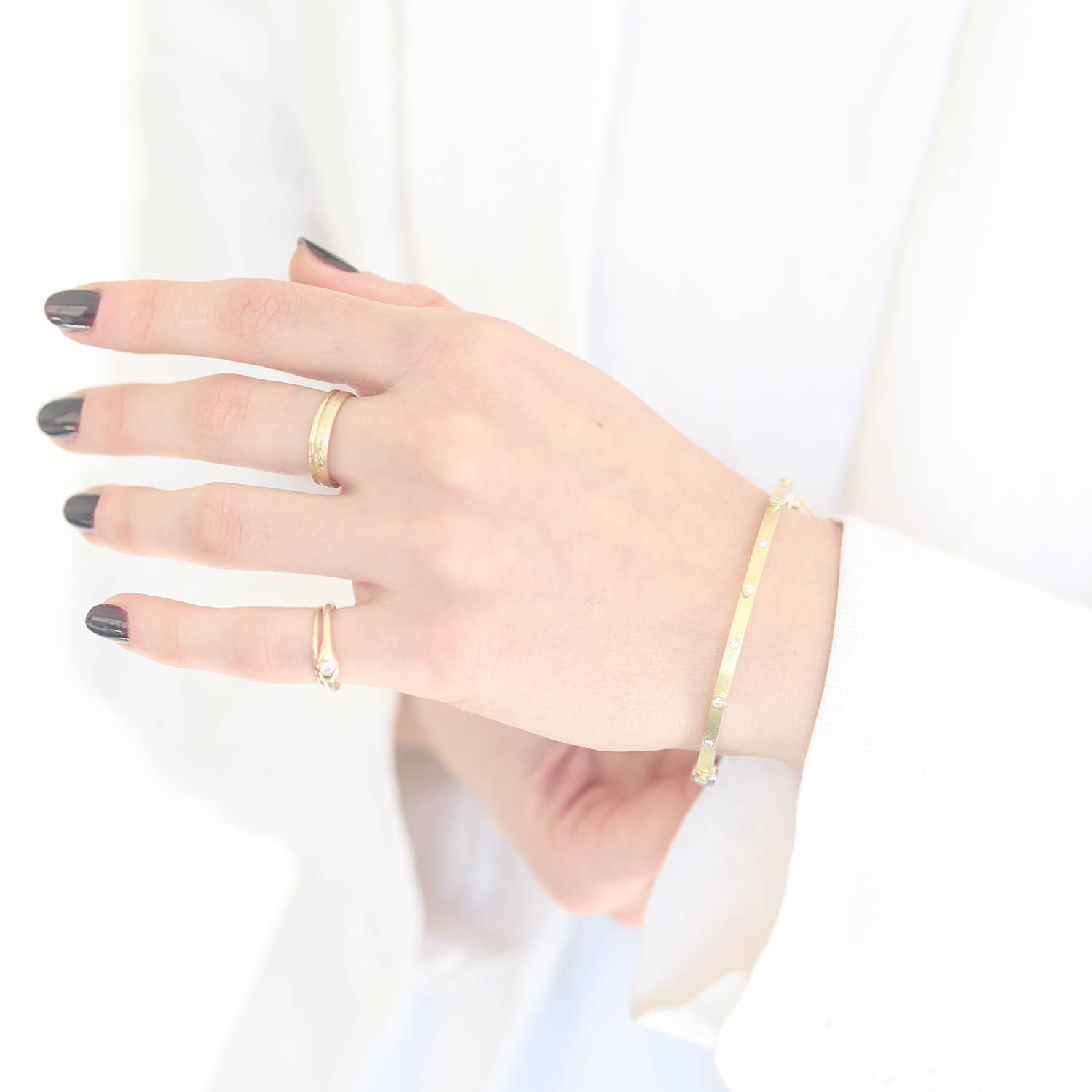 Rene Escobar Trunk Show:26 0.20CT 2.5MM. SS hinged bangle featuring an 18k YG push button style clasp and 18k YG top sheet and bezels set with 0.20CT in WH diamonds.