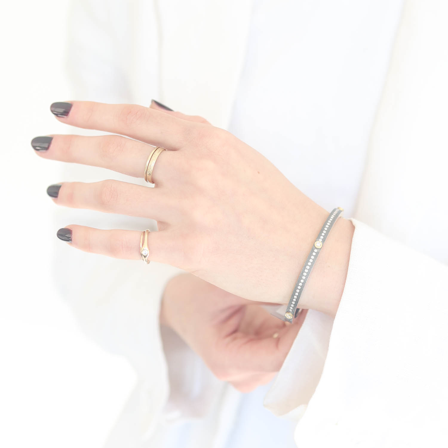 Rene Escobar Trunk Show:29 0.45CT 4MM. SS hinged bangle featuring an 18k YG push button style clasp and 3 18k YG bezels set with 0.45CT in WH diamonds.