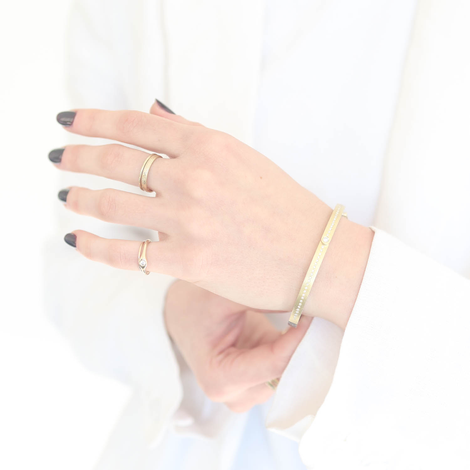 Rene Escobar Trunk Show:36 4MM. SS hinged bangle featuring an 18k YG push button style clasp and a solid 18k YG top sheet and bezel set with RND cut with 0.35CT of WH diamonds.
